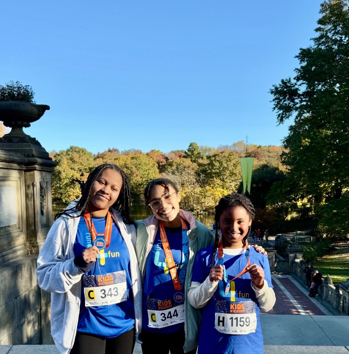 Leah with two fellow Run4Fun runners holding their medals in Central Park