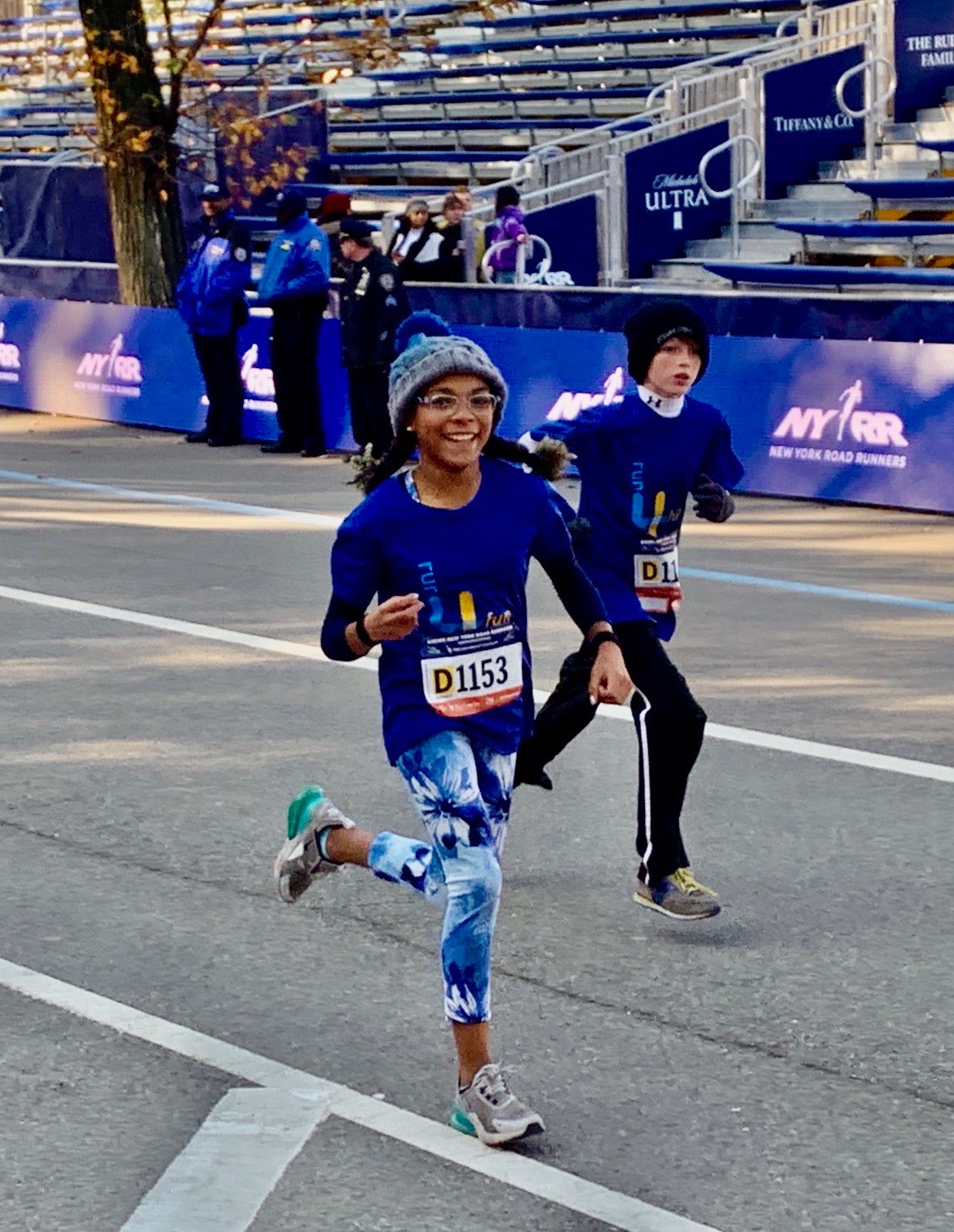 Two Run4Fun runners smiling as they finish a New York Road Runners youth race